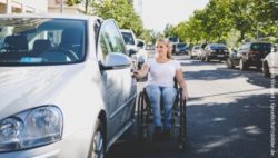 Foto: Junge Frau im Rollstuhl öffnet Fahrertür eines Autos, in das sie einsteigen möchte; Copyright: visitBerlin, Andi Weiland | Gesellschaftsbilder.de