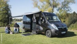 Foto: Ein Mann im Rollstuhl und eine Frau mit Hund sitzen vor ihrem barrierefreien Reisemobil; Copyright: Sodermanns