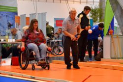 Bild: Eine Rollstuhl-Fahrerin probiert sich im Boccia; Copyright: beta-web/Hofmann