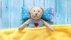 Foto: Ein Teddybär unter einer Decke; Copyright: PantherMedia/Mukhomedianova